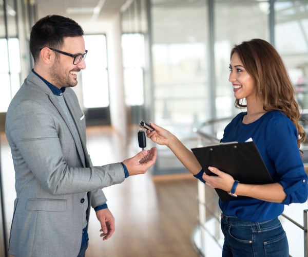 car-dealer-handing-keys-vehicle-buyer
